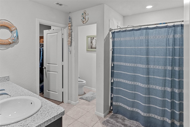 bathroom with a shower with shower curtain, vanity, tile patterned flooring, and toilet