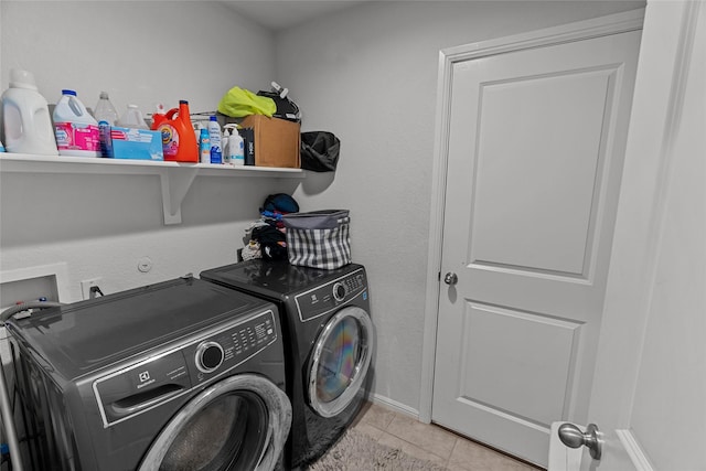 laundry area featuring washing machine and clothes dryer and light tile patterned flooring