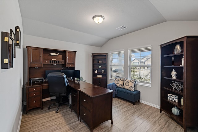 office space with light wood-type flooring and vaulted ceiling