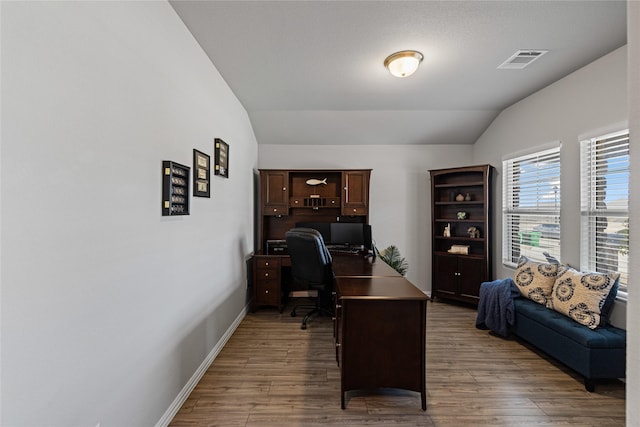 office featuring lofted ceiling and dark hardwood / wood-style flooring