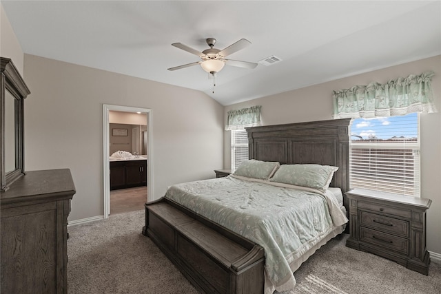 bedroom with carpet, vaulted ceiling, ensuite bathroom, and ceiling fan