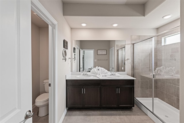 bathroom featuring vanity, a shower with door, toilet, and tile patterned floors