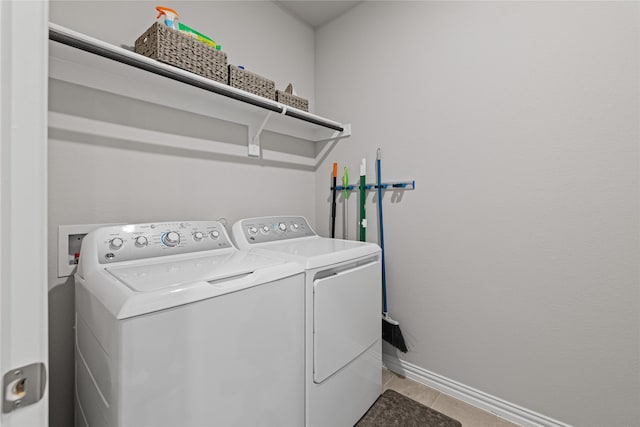 washroom with light tile patterned floors and washer and dryer