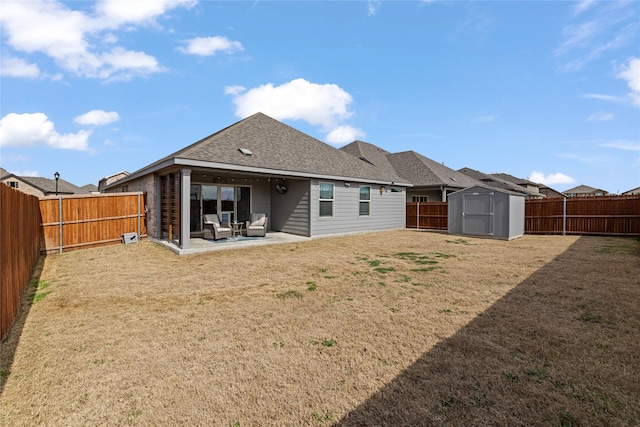 rear view of house with a storage unit, a patio, and a yard