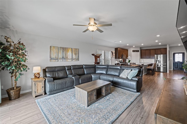 living room featuring ceiling fan and light hardwood / wood-style flooring