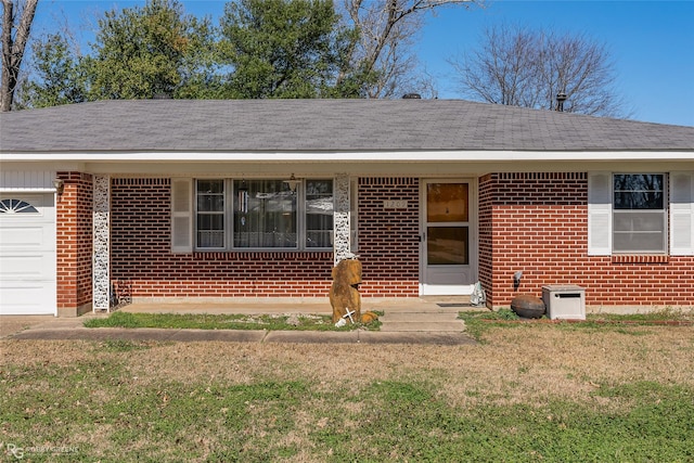 view of exterior entry with a garage and a lawn