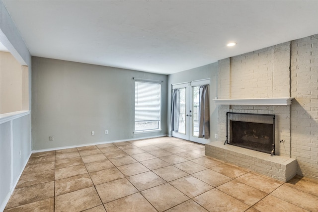 unfurnished living room with french doors, recessed lighting, a brick fireplace, light tile patterned flooring, and baseboards