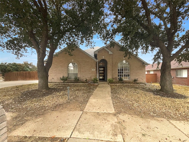 view of front of property featuring brick siding and fence