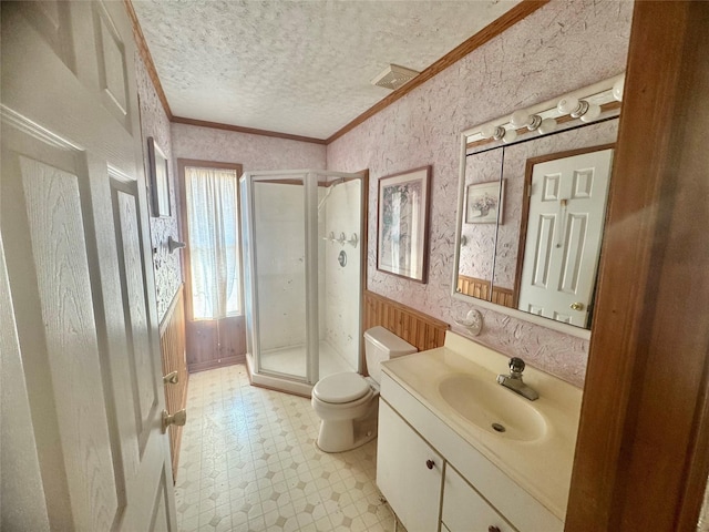 bathroom with vanity, walk in shower, a textured ceiling, toilet, and ornamental molding