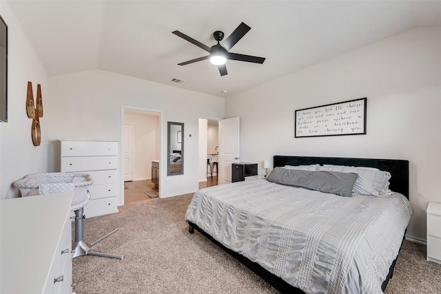 carpeted bedroom featuring vaulted ceiling, ceiling fan, and ensuite bath