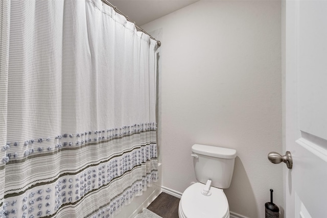 bathroom with hardwood / wood-style flooring and toilet