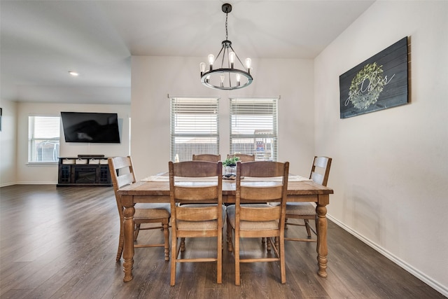 dining area with dark wood-type flooring and a notable chandelier