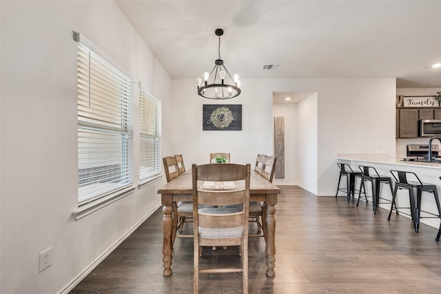 dining room featuring dark hardwood / wood-style flooring and a chandelier