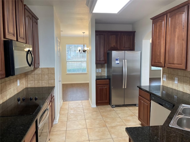 kitchen with backsplash, a notable chandelier, light tile patterned flooring, decorative light fixtures, and black appliances