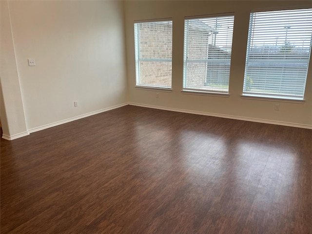 empty room with plenty of natural light and dark wood-type flooring