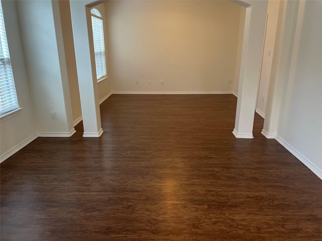 spare room featuring dark hardwood / wood-style flooring and plenty of natural light