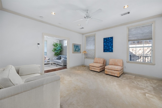 living room with light colored carpet, ceiling fan, and ornamental molding