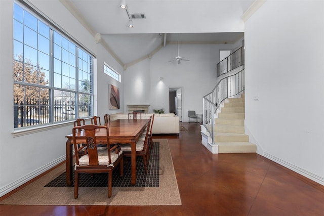 dining area featuring beam ceiling, high vaulted ceiling, a wealth of natural light, and ceiling fan