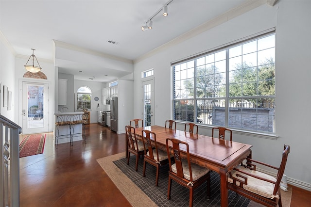 dining room featuring rail lighting and ornamental molding