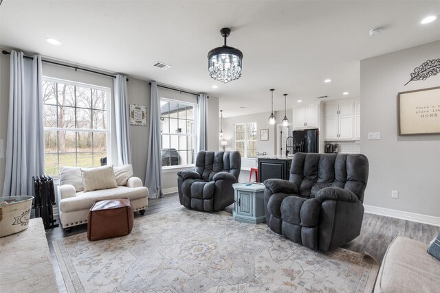 656 Calmwater Ct, Mabank, TX 75143 - living room featuring baseboards, recessed lighting, light wood finished floors, and an inviting chandelier
