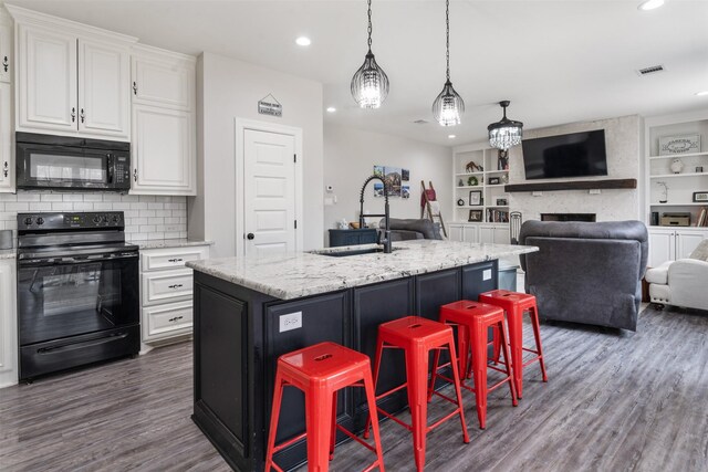 656 Calmwater Ct, Mabank, TX 75143 - kitchen featuring dark wood finished floors, a sink, white cabinets, black appliances, and open floor plan