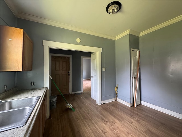2917 Walnut St, Greenville, TX 75401 - kitchen featuring a sink, ornamental molding, dark wood finished floors, light countertops, and baseboards