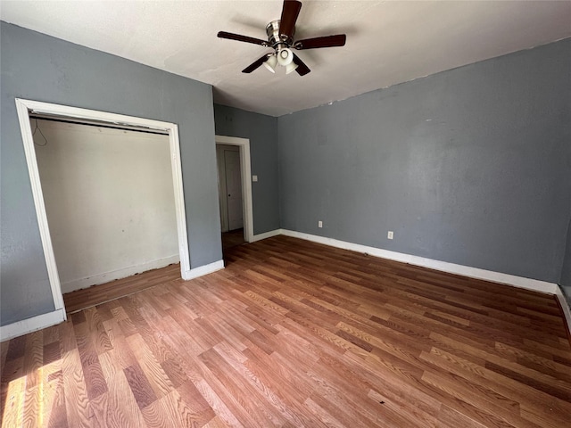2917 Walnut St, Greenville, TX 75401 - unfurnished bedroom featuring wood finished floors, baseboards, a ceiling fan, and a closet