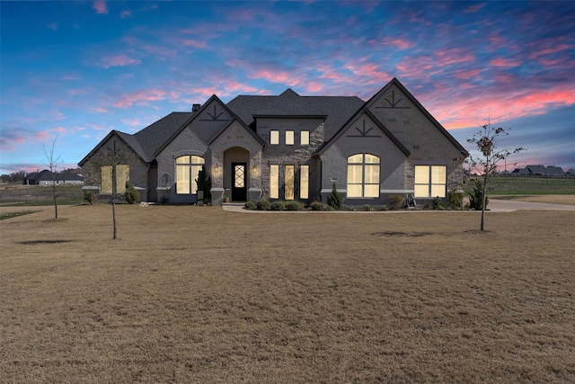 french country style house featuring a lawn