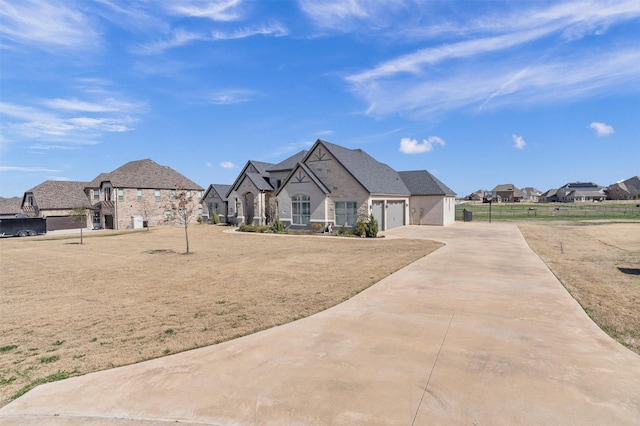 french country inspired facade featuring a front yard and a garage