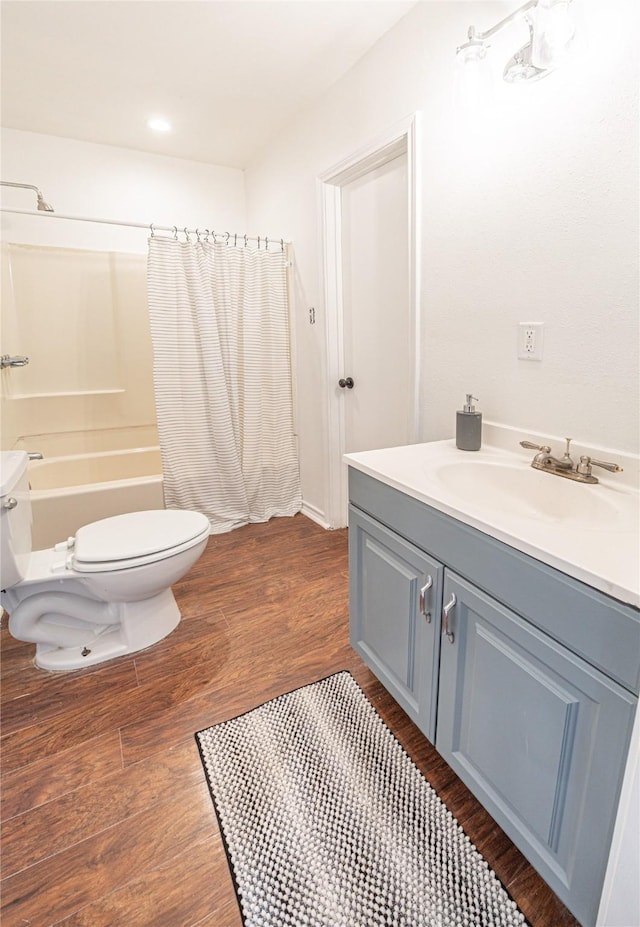 full bathroom featuring hardwood / wood-style floors, toilet, vanity, and shower / bath combination with curtain