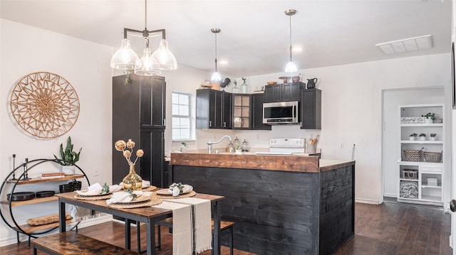 kitchen with sink, electric stove, pendant lighting, and dark wood-type flooring