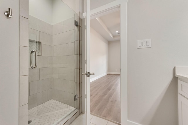 bathroom featuring hardwood / wood-style flooring, vanity, and a shower with shower door