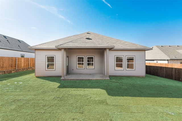 rear view of house with a patio and a lawn