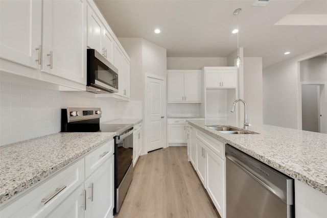 kitchen with sink, appliances with stainless steel finishes, white cabinets, and light stone counters