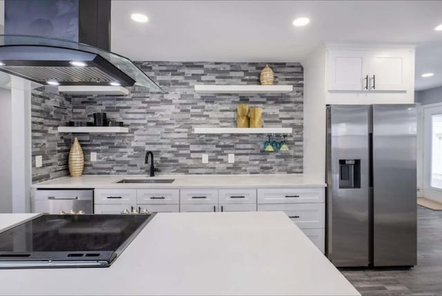 kitchen featuring sink, island exhaust hood, stainless steel appliances, white cabinets, and tasteful backsplash