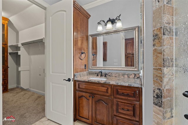 bathroom featuring ornamental molding, vanity, and a shower