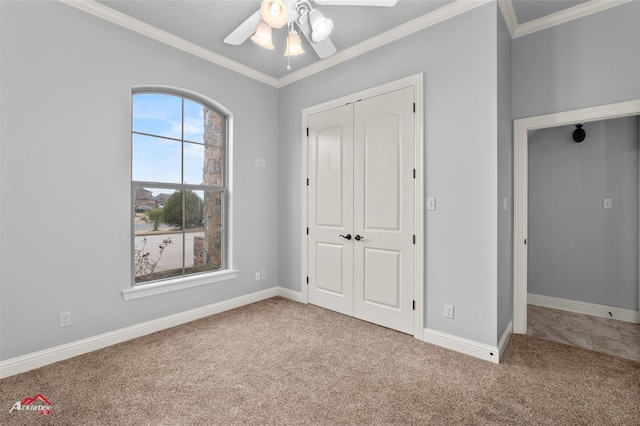 unfurnished bedroom featuring ceiling fan, crown molding, carpet, and a closet