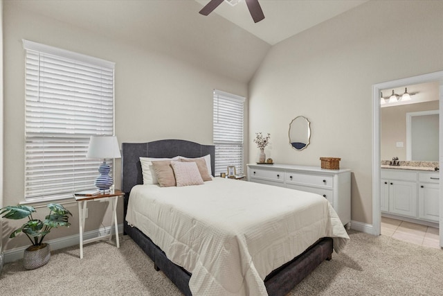 bedroom featuring lofted ceiling, light colored carpet, sink, ceiling fan, and ensuite bathroom