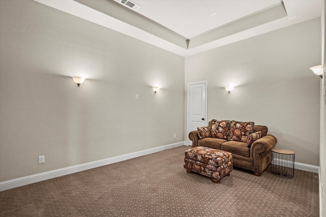 living room featuring a raised ceiling and carpet