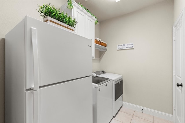 laundry area featuring light tile patterned flooring, cabinets, and washer and dryer