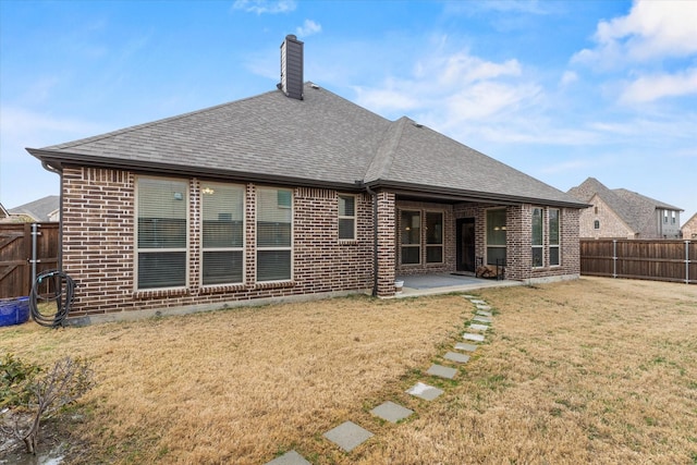 rear view of property featuring a patio and a yard