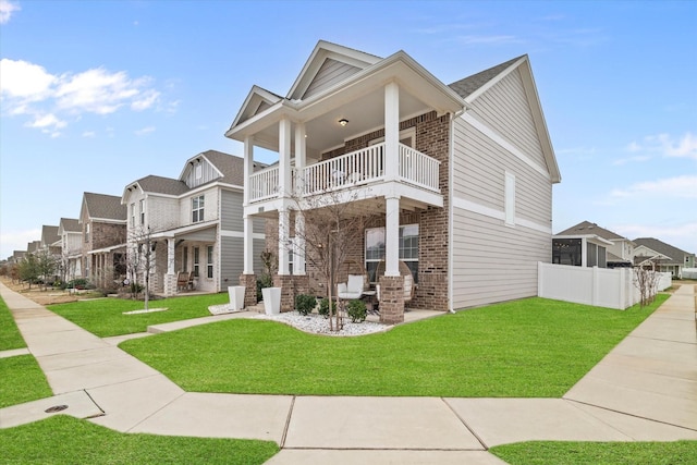 view of front of home featuring a balcony and a front lawn