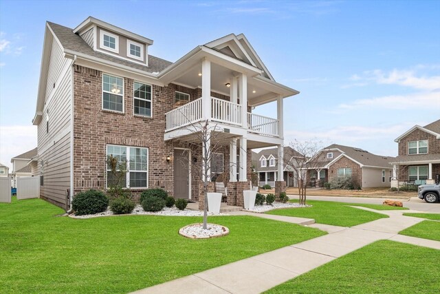 10012 Travis Dr, Providence Village, TX 76227 - view of front of house featuring a balcony, a front yard, and brick siding