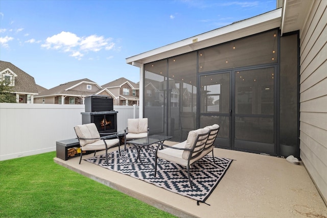 view of patio / terrace with exterior fireplace and a sunroom