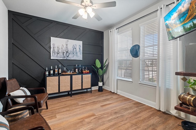 living area featuring ceiling fan and light hardwood / wood-style flooring