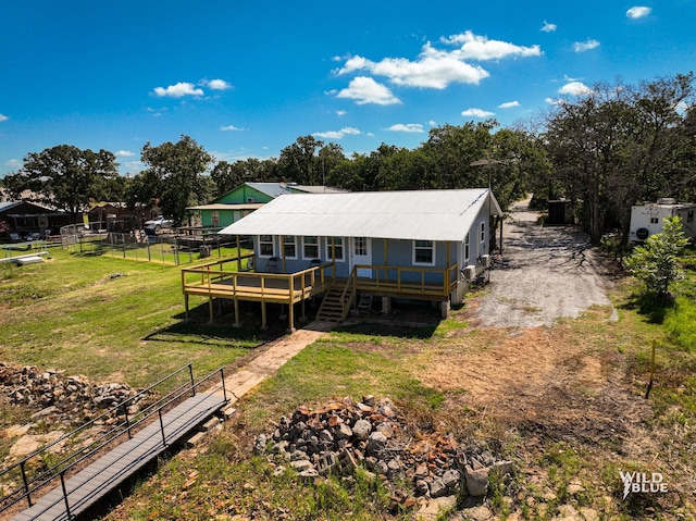 back of property featuring stairway, a deck, and a lawn