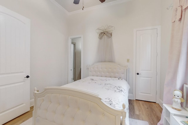 bedroom featuring ceiling fan, light wood-type flooring, and crown molding