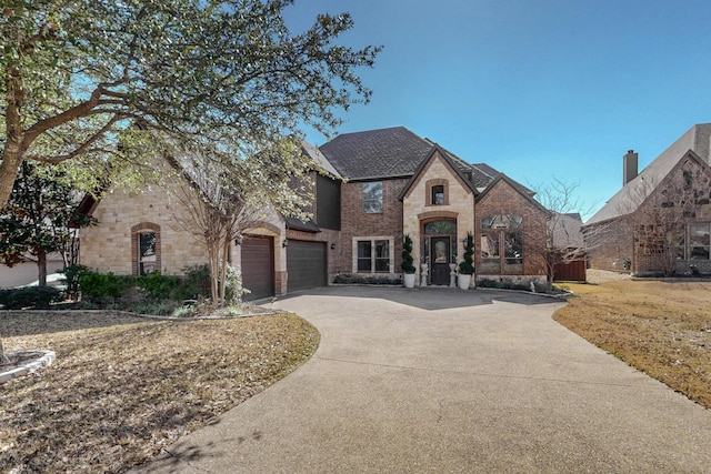 788 Windsong Ln, Rockwall, TX 75032 - french country style house featuring concrete driveway, a garage, brick siding, and stone siding