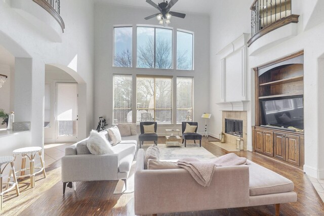 788 Windsong Ln, Rockwall, TX 75032 - living area featuring a high ceiling, ceiling fan, arched walkways, a fireplace, and wood finished floors
