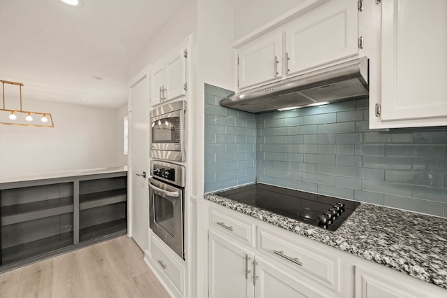 kitchen featuring white cabinetry, light wood-type flooring, stainless steel appliances, stone countertops, and pendant lighting